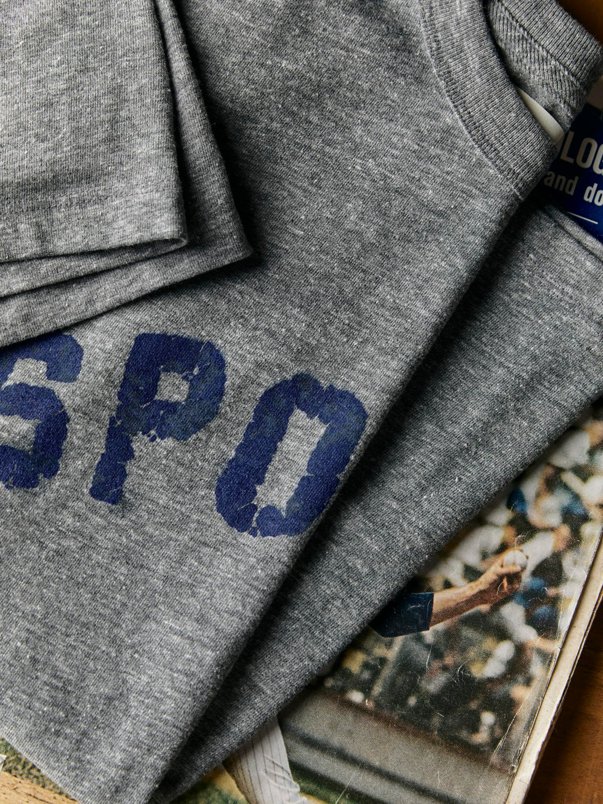 Close-up flat lay of the distressed 'SPO' lettering with vintage sports magazine underneath