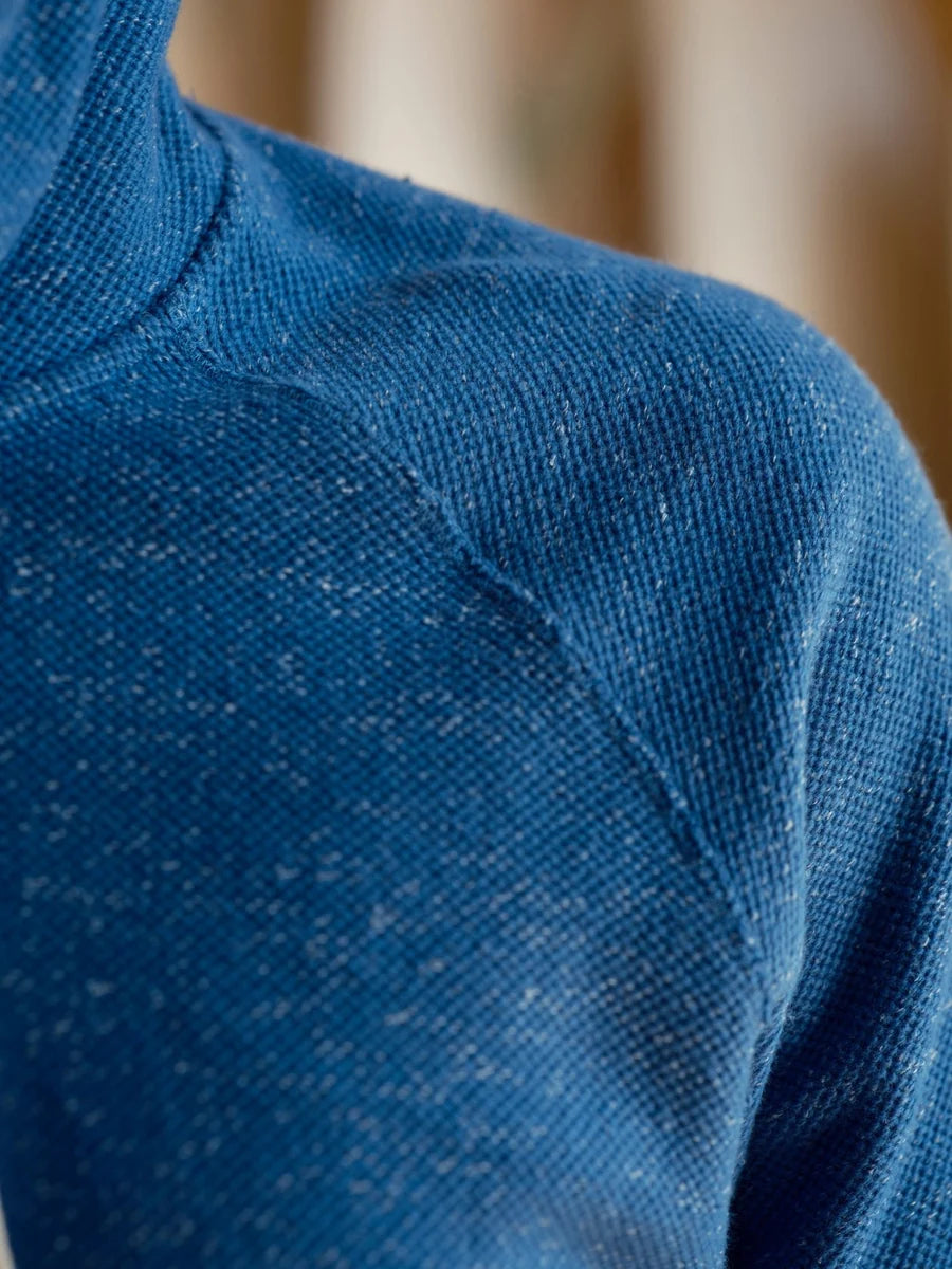 Close-up detail of the Mollusk Surf Shop Whale Patch Pullover in Marine, showing the nubby twisted French terry fabric texture and raglan shoulder seam in marine blue