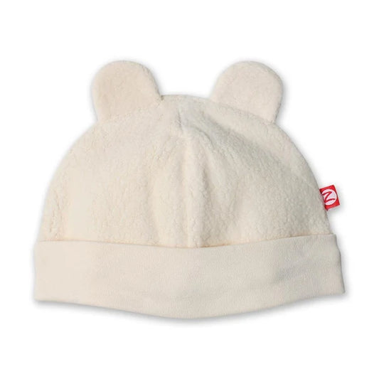 Zutano Cream fleece baby hat with two rounded bear ears, a wide folded band and a small red brand tag.
