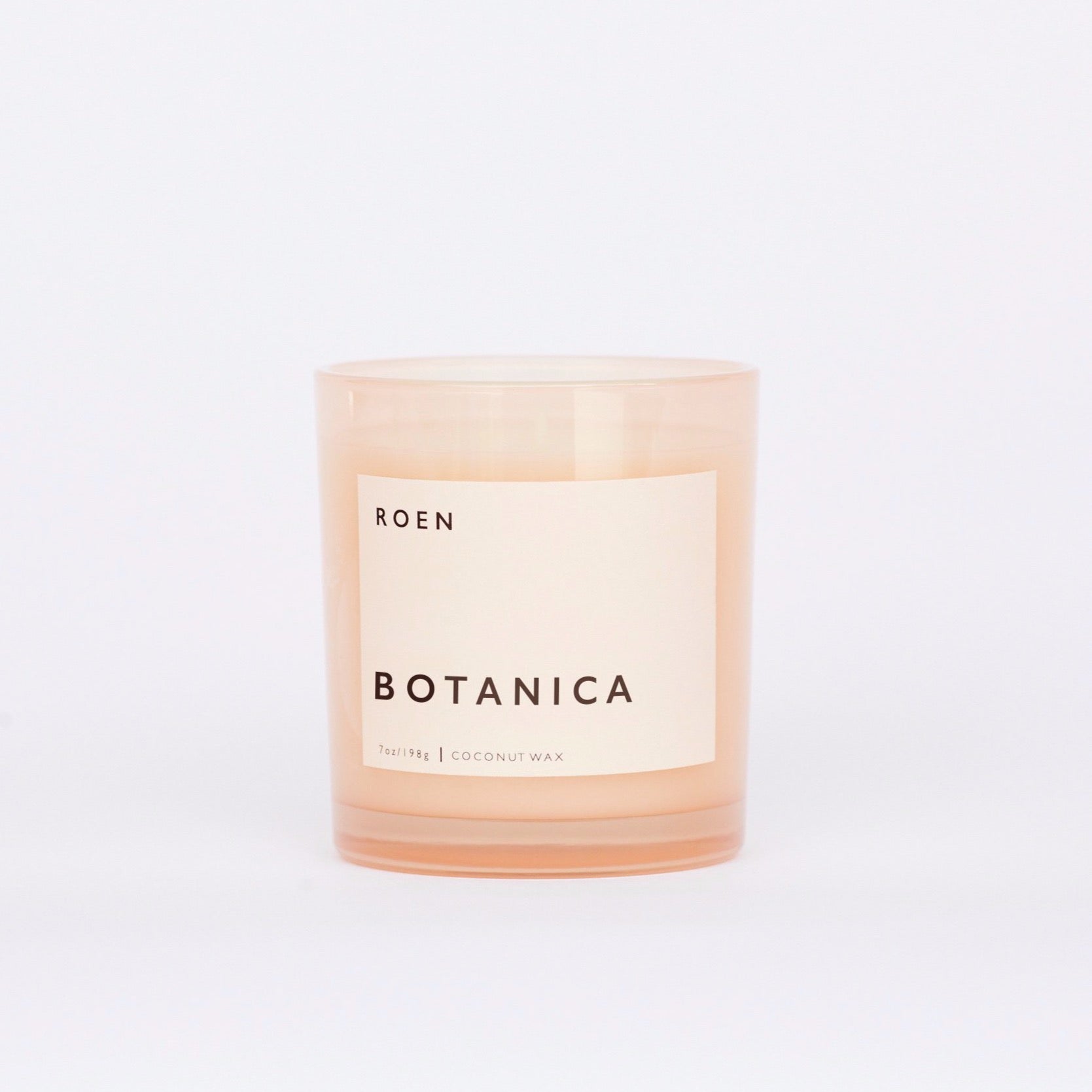 Front facing shot of Roen's Botanica scented candle in a pink glass jar with a light pink label and black font reading "Botanica".