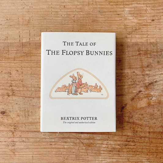The book 'The tale of flopsy bunnies laydown' cover shot top view on wooden background