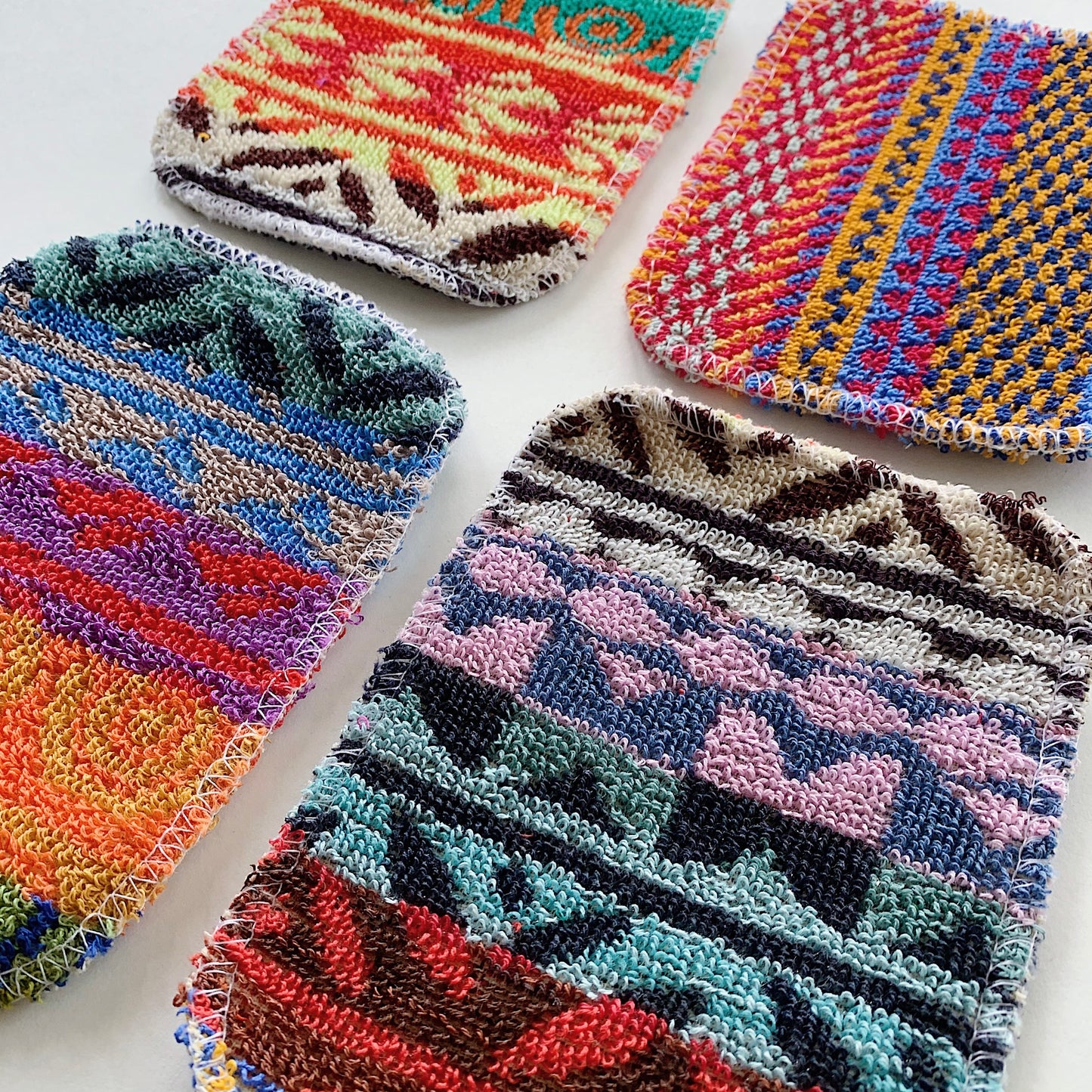 Four scrubby pads lying side by side shot from a low diagonal view looking across to see the detail of the fibers.