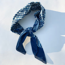 Load image into Gallery viewer, Over head shot of cotton bandana in a diamond trail pattern in indigo
