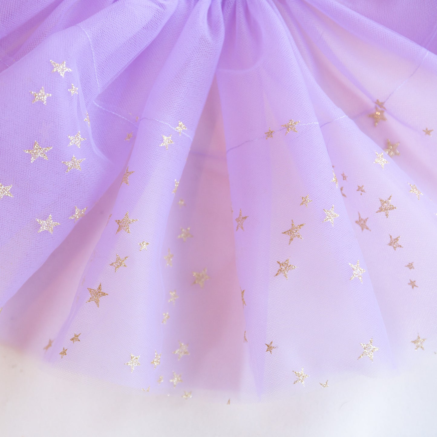 A purple tutu with gold stars and an elastic waistband.