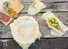 Load image into Gallery viewer, bee&#39;s wrap assorted 3 pack in situ with food on tabletop background
