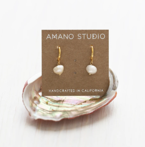 amano studio pearl hoops seen in packaging sitting in an oyster shell