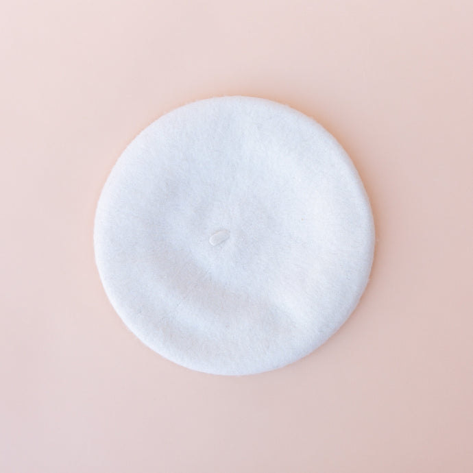 overhead view of wool beret in white